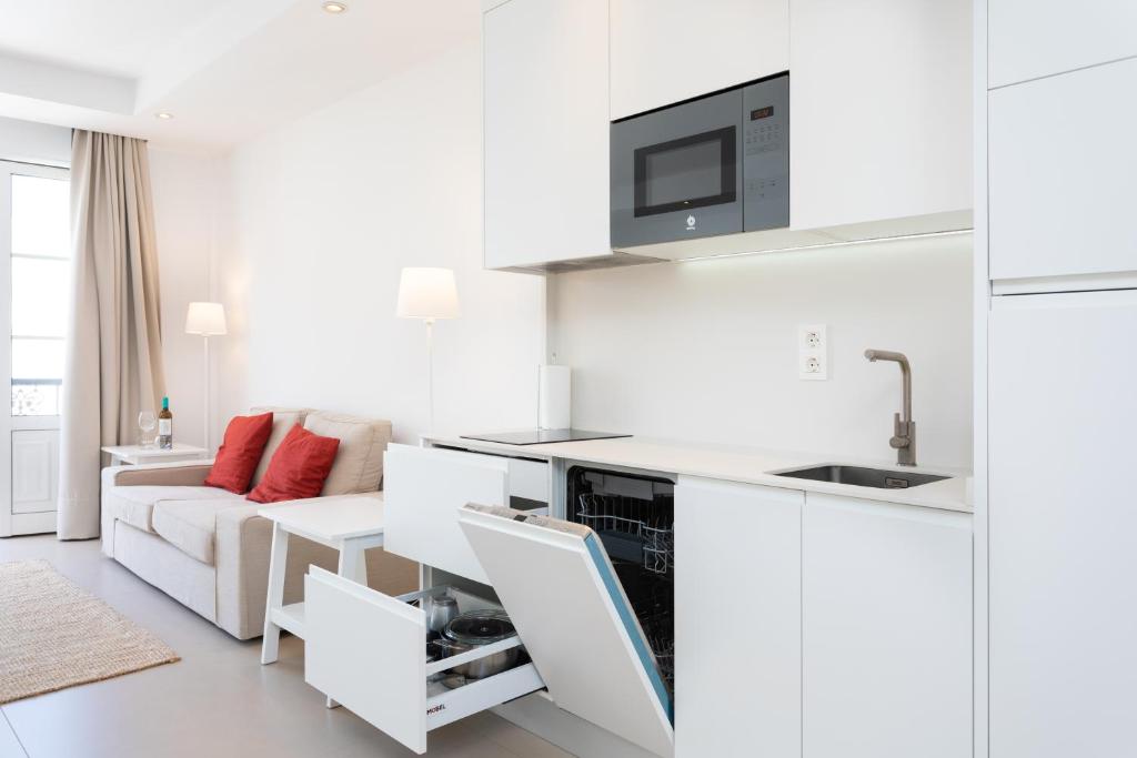 a white living room with a couch and a kitchen at Rooms & Suites Loft 2G Deluxe Edition Arrecife in Arrecife