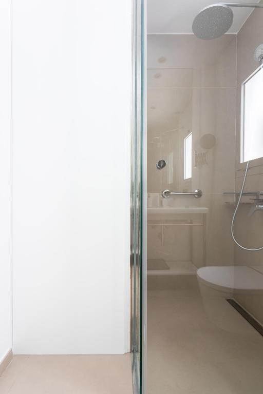a bathroom with a shower and a toilet and a sink at Rooms & Suites Loft 2G Deluxe Edition Arrecife in Arrecife