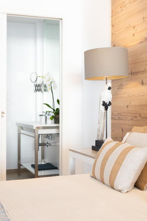 a bedroom with a bed with a lamp and a desk at Rooms & Suites Loft 2G Deluxe Edition Arrecife in Arrecife