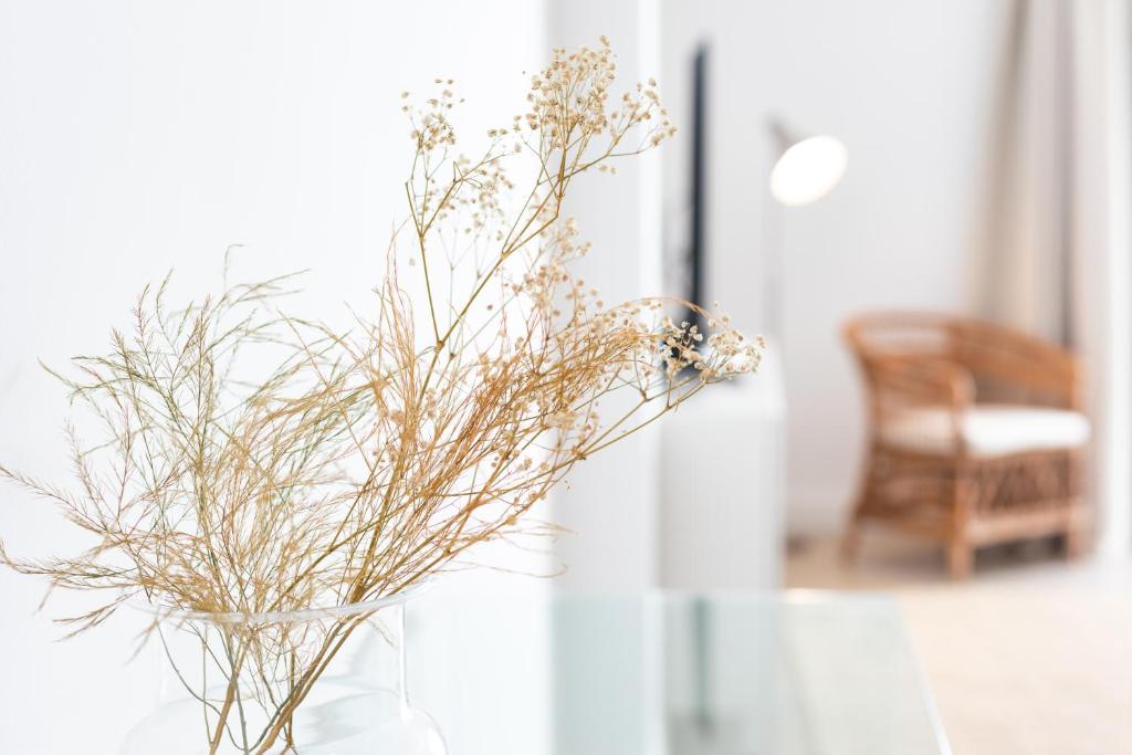 a vase filled with dried flowers sitting on a table at Rooms & Suites Loft 2G Deluxe Edition Arrecife in Arrecife
