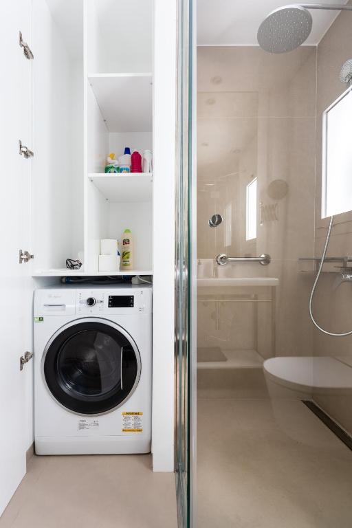 a washing machine in a bathroom with a shower at Rooms & Suites Loft 2G Deluxe Edition Arrecife in Arrecife
