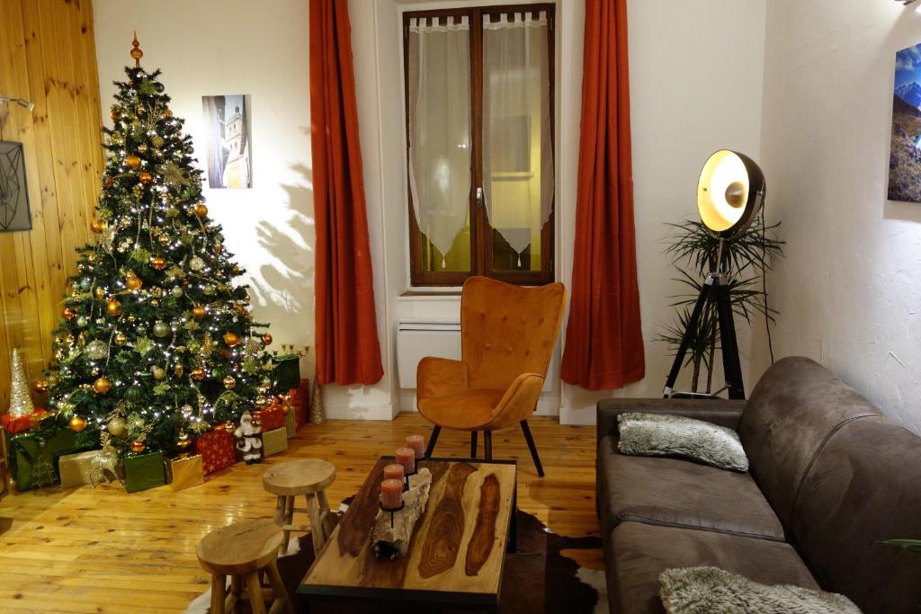 a living room with a christmas tree and a couch at Appartement cosy montagne, centre ville de Briançon in Briançon