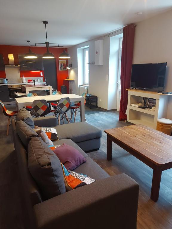 ein Wohnzimmer mit einem Sofa und einem Tisch in der Unterkunft Maison de bourg paisible in Parçay-sur-Vienne