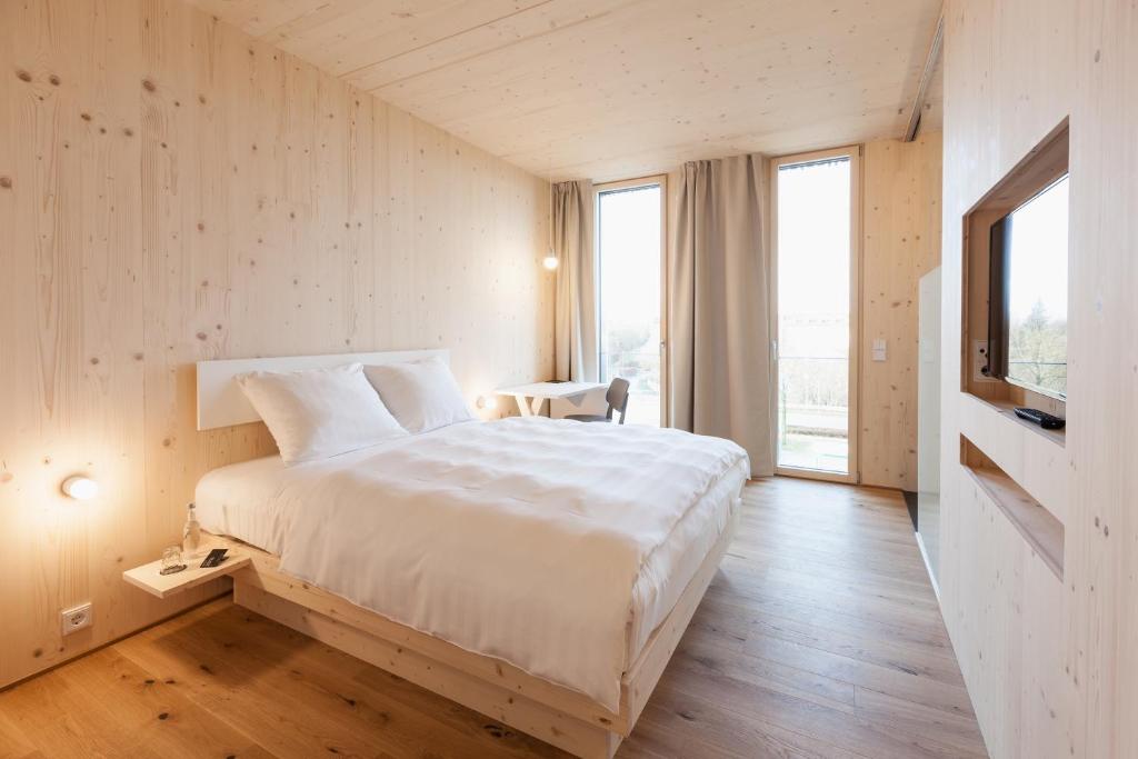 um quarto com uma grande cama branca e uma janela em Bader Hotel em Parsdorf