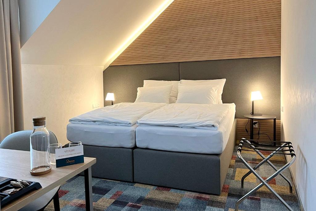 Dieses Hotelzimmer verfügt über ein Bett, einen Schreibtisch und ein Bett der Marke sidx sidx sidx sidx sidx. in der Unterkunft Duran Penzion in Hradec Králové