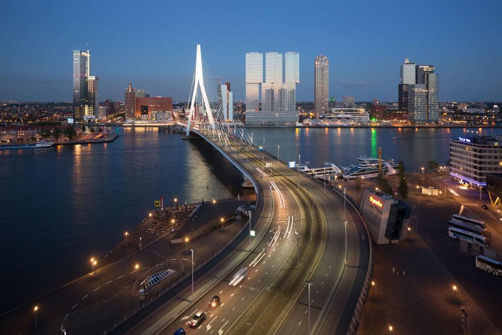 eine Brücke über einen Fluss mit Verkehr auf einer Autobahn in der Unterkunft nhow Rotterdam in Rotterdam