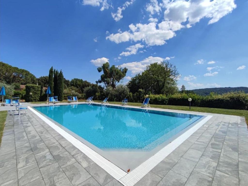 uma piscina com cadeiras e um céu azul em Property in Gambassi Terme FI em Gambassi Terme