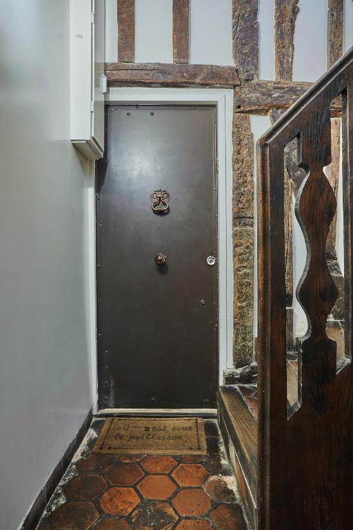 a black door in a hallway next to a building at Apartment in heart of Marais by Studio prestige in Paris