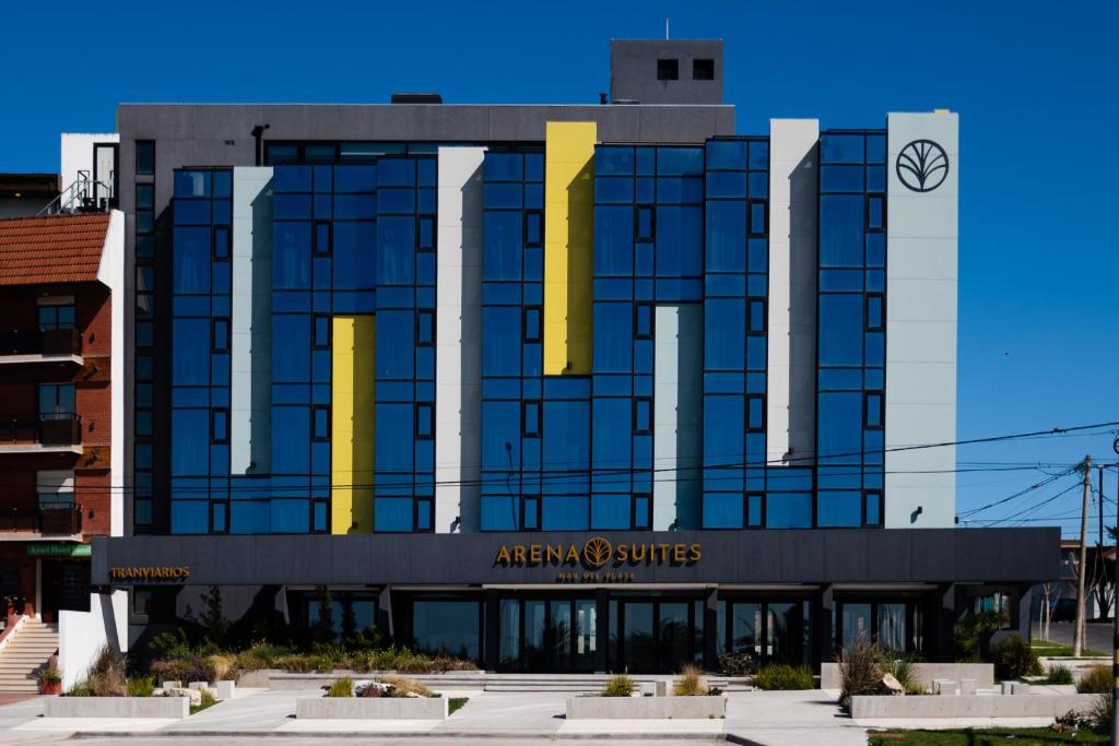 a building with yellow columns on the front of it at Arena Suites in Mar del Plata