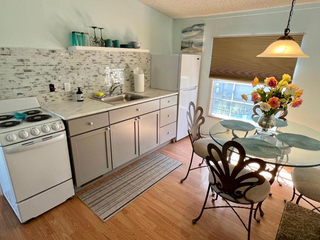 uma cozinha com uma mesa e um forno de fogão branco em Gray Heron House em Charleston