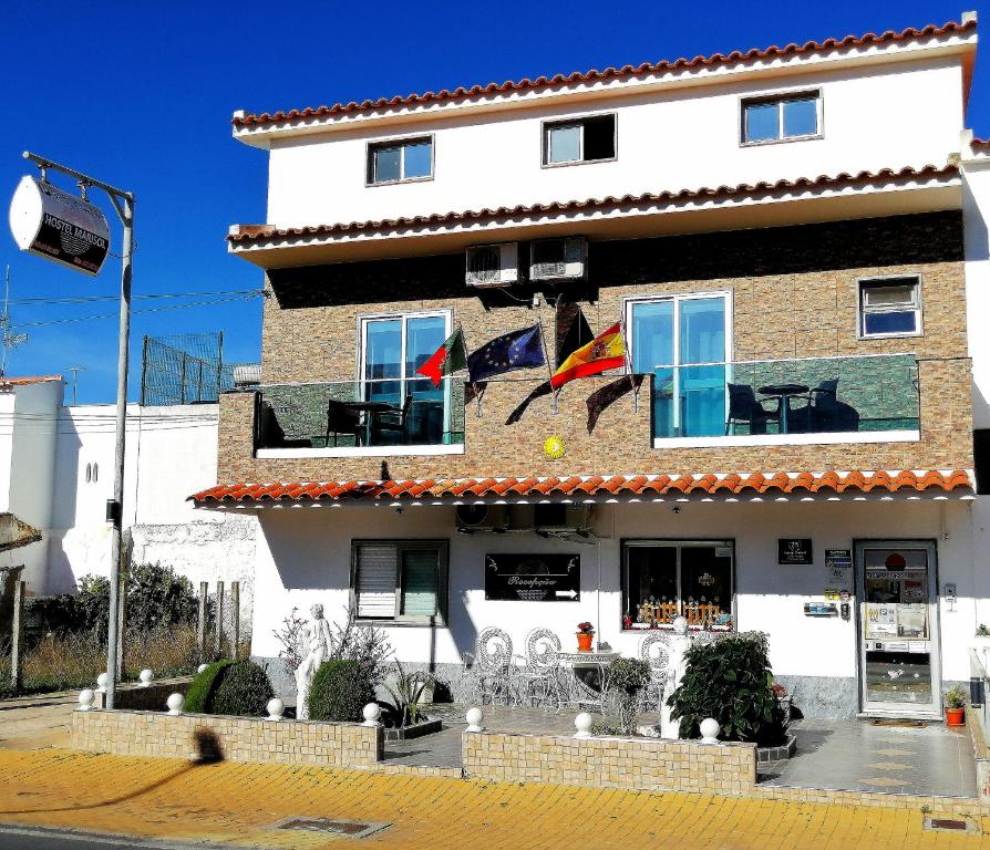 um edifício com uma bandeira à sua frente em Hostel Boutique Marisol em Monte Gordo