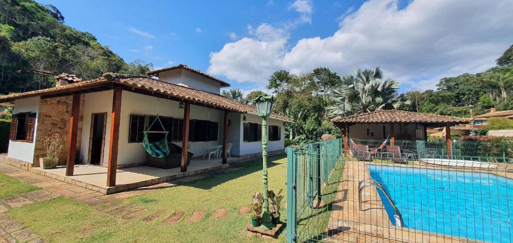 a house with a swimming pool next to a house at Casa Família, piscina, hidro aquecida, cercada in Petrópolis