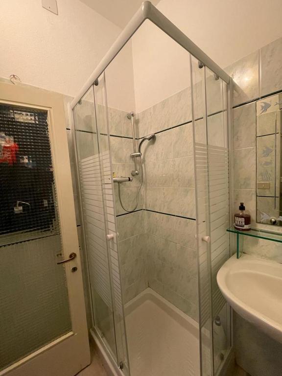 łazienka z przeszkloną kabiną prysznicową i umywalką w obiekcie La Casina di TRILLI w Rapallo