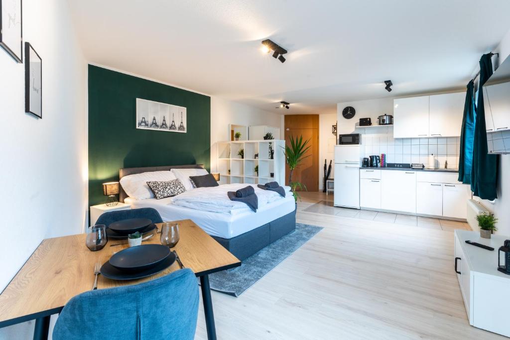 a bedroom with a bed and a table and a kitchen at Mercedes I Stuttgart I Kitchen I Home Office I Parkplatz in Böblingen