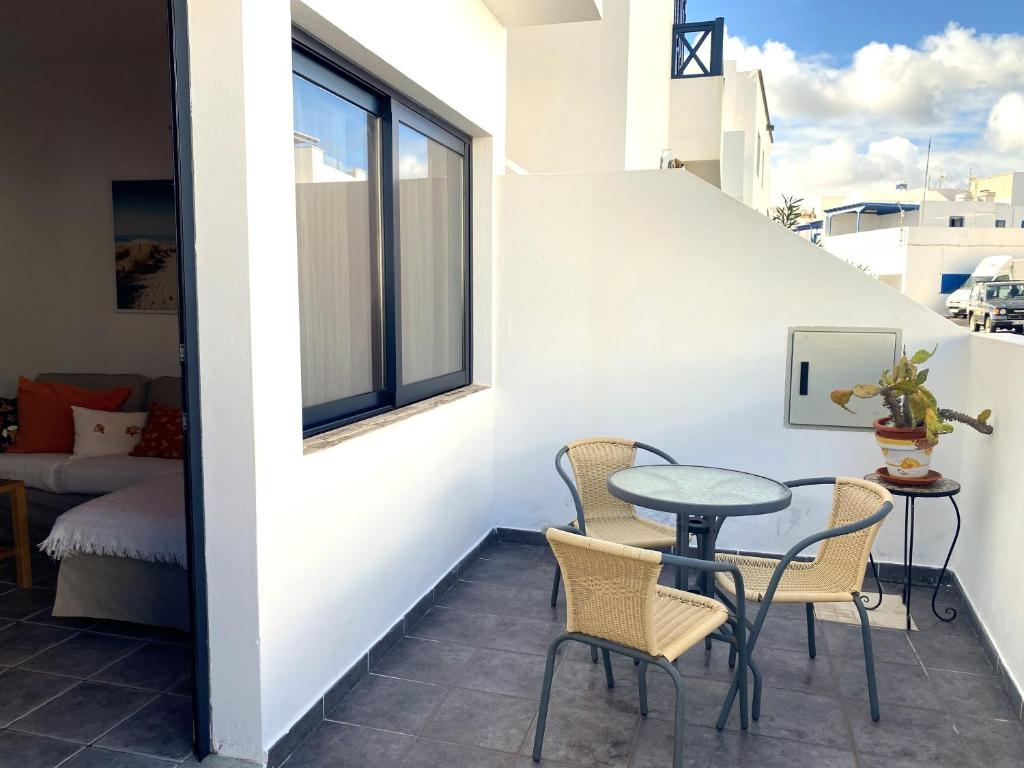 Elle comprend un petit balcon avec une table, des chaises et un lit. dans l'établissement APARTAMENTO SOL PLAYA, à Punta de Mujeres