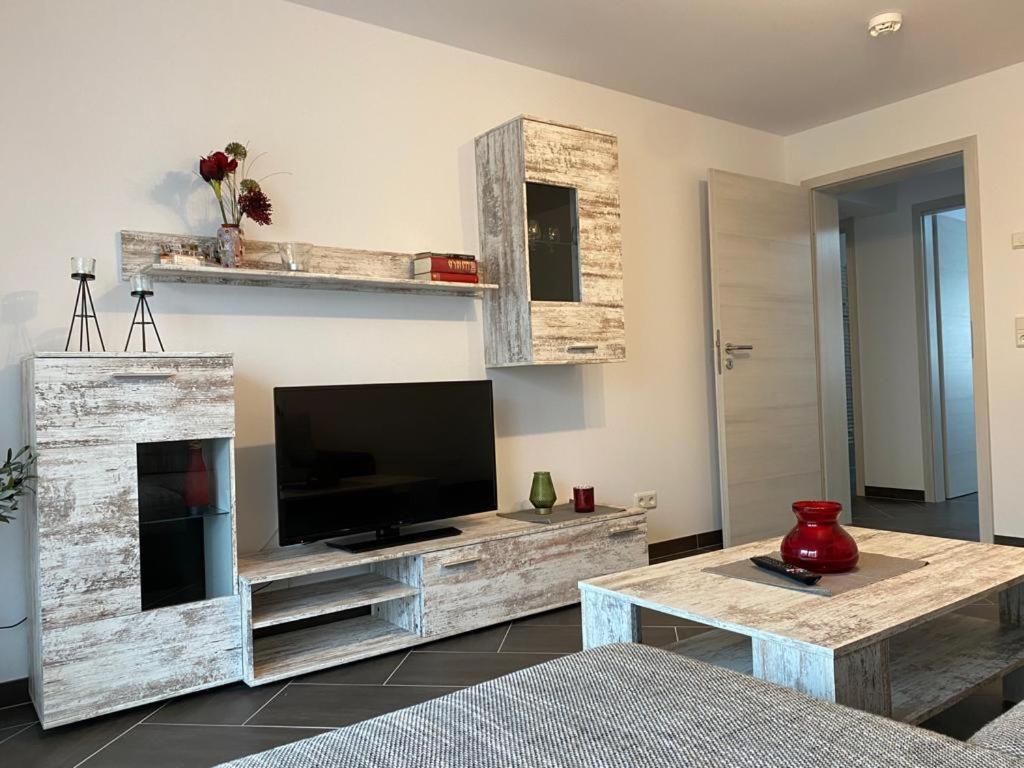 een woonkamer met een televisie en een tafel bij Gästewohnung 3 in Oschersleben