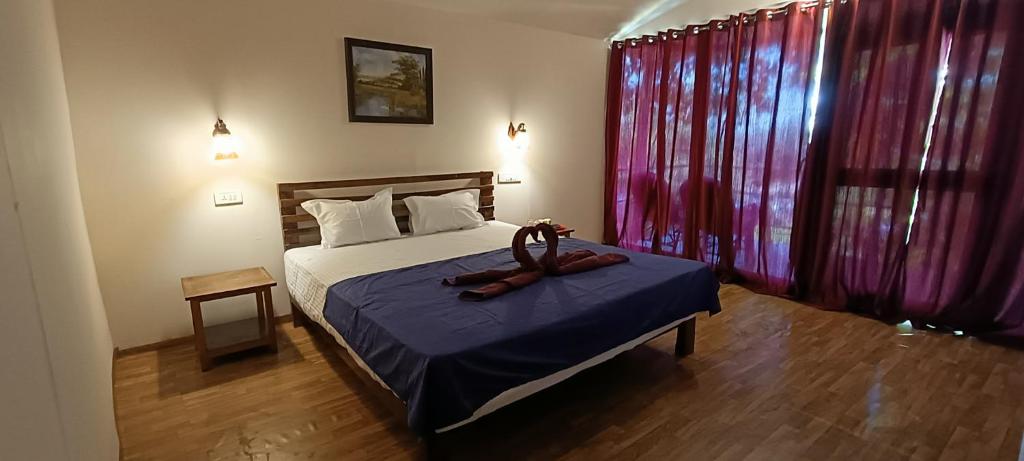a bedroom with a bed with a pair of shoes on it at BRAMHA COTTAGES in Canacona
