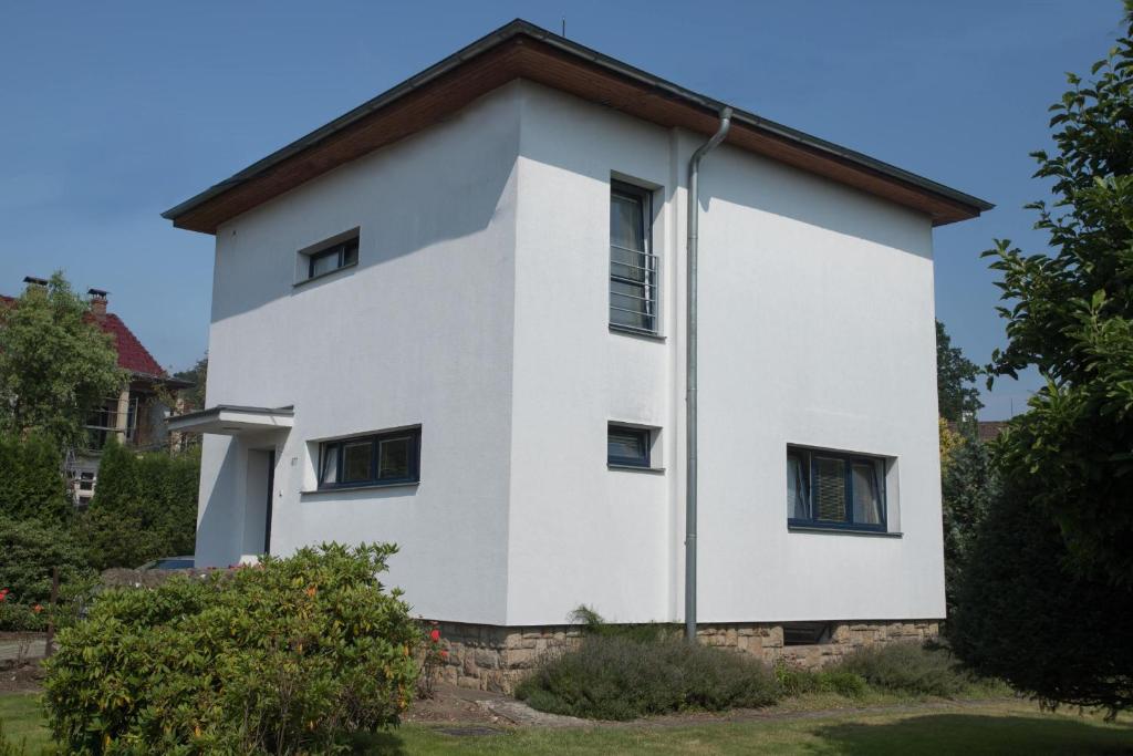 biały budynek z brązowym dachem w obiekcie Penzion Garni w mieście Rožnov pod Radhoštěm
