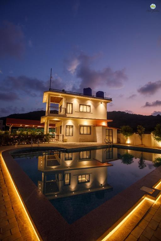 a house with a swimming pool at night at Eden Garden in Alibaug