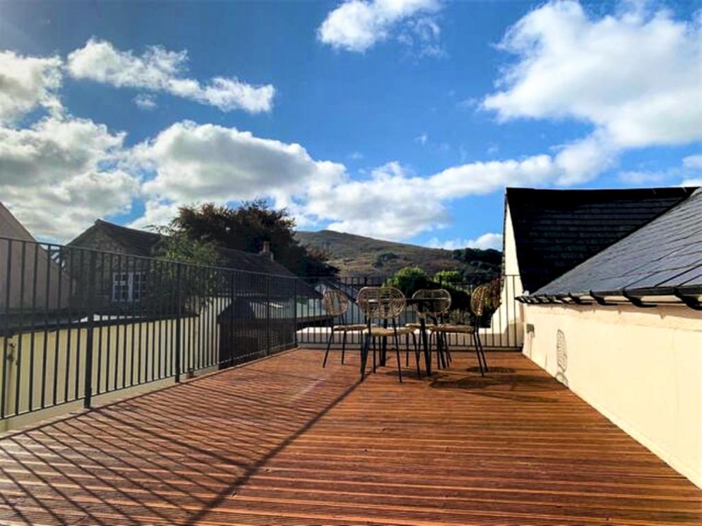 a wooden deck with chairs and a table on it at Pass the Keys Meldon View Period Dartmoor apartment with large roof terrace in Newton Abbot