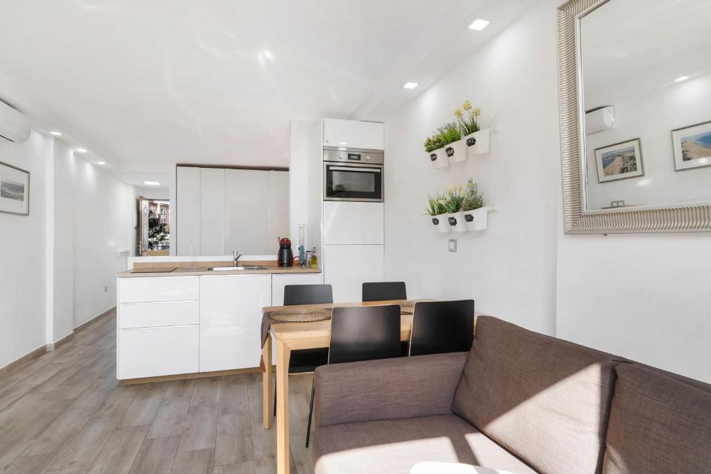 a kitchen and living room with a couch and a table at Los Molinos 202 in Maspalomas