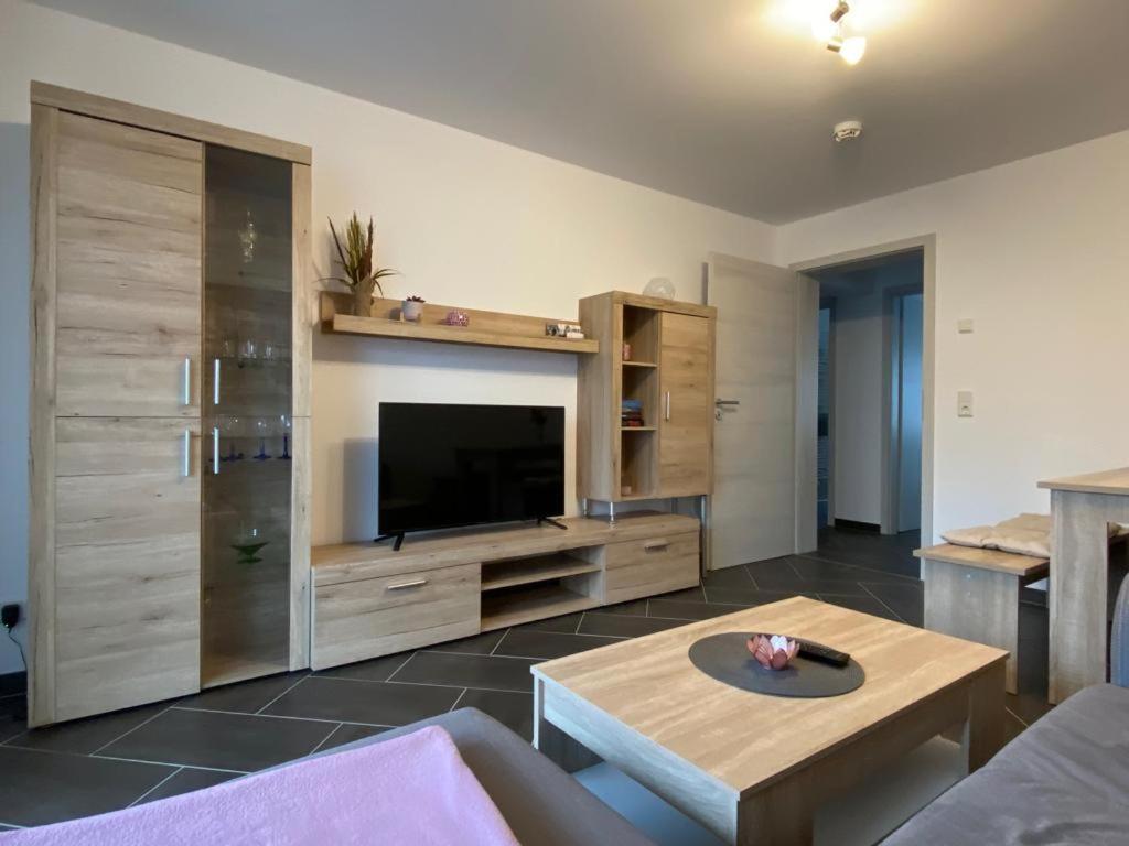 ein Wohnzimmer mit einem TV, einem Sofa und einem Tisch in der Unterkunft Gästewohnung 4 in Oschersleben