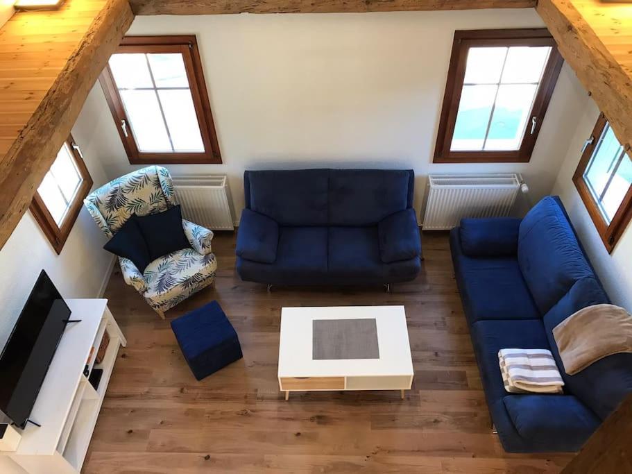 a living room with a blue couch and a table at La Maisonnette : charmante maison indépendante in Salgesch