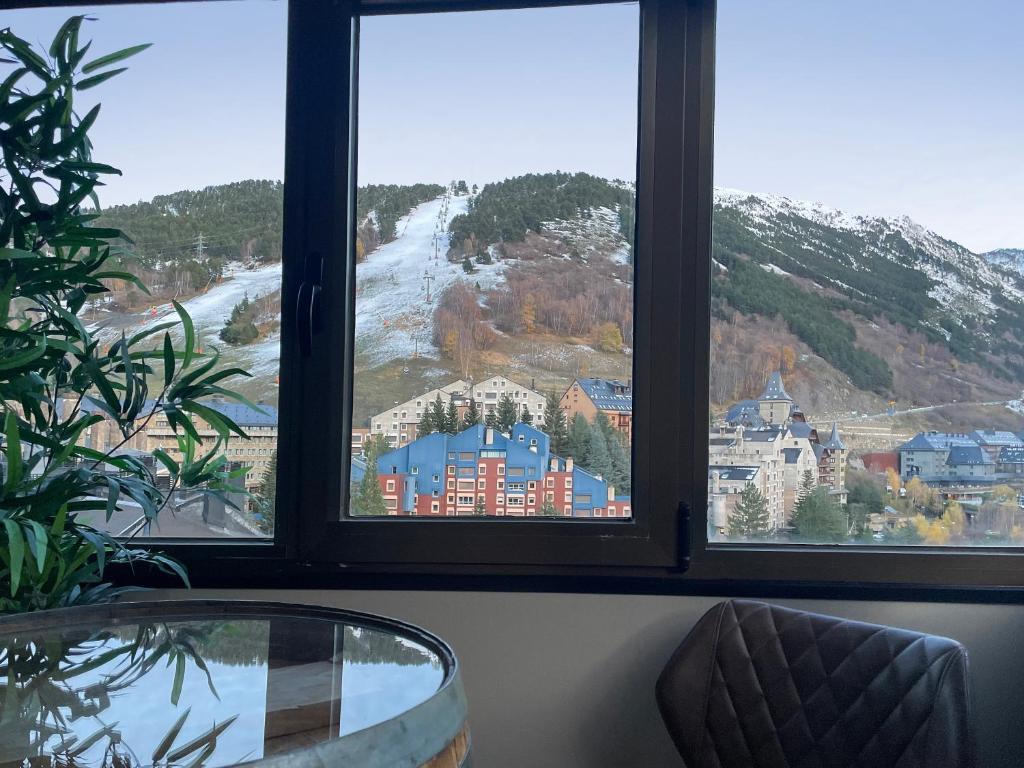 uma vista para uma montanha a partir de um quarto com duas janelas em Apartamento Baqueira pie pistas cota 1500 em Baqueira-Beret