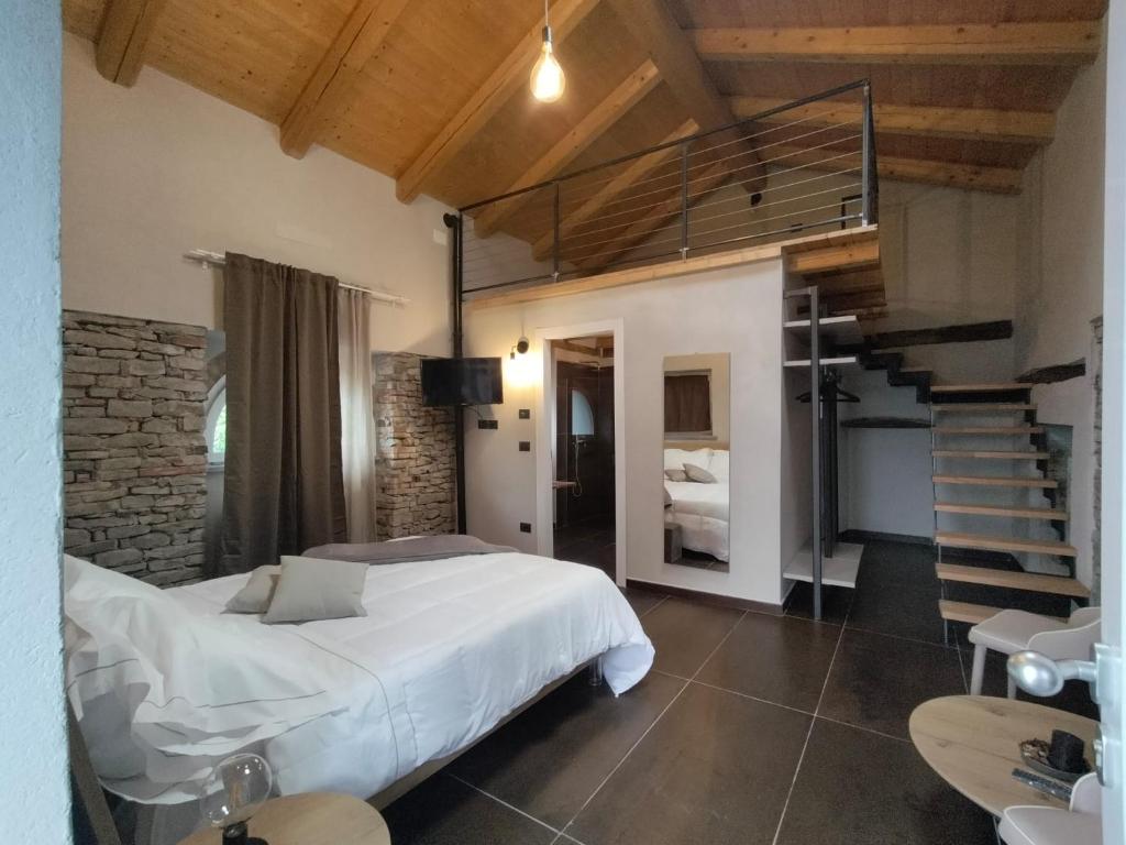 a bedroom with a large bed and a staircase at Dimora DarSenso in Albaretto Della Torre 