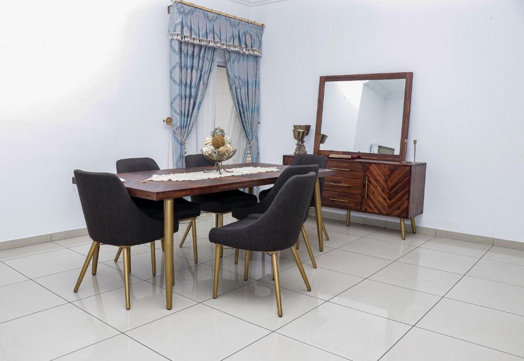 a dining room with a table and chairs and a mirror at the Waldorf Astoria 5 Alema avenue in Accra