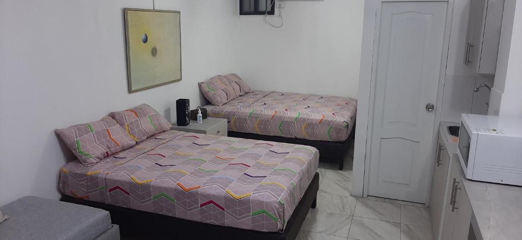 Habitación pequeña con cama y sofá en Perla's Suites, en Guayaquil
