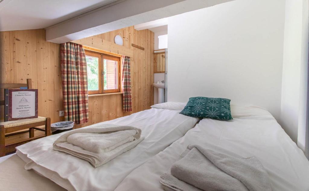 a bedroom with a bed with towels on it at Hotel Le Chamois in L&#39;Alpe-d&#39;Huez