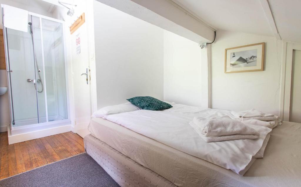 a small bedroom with a bed and a window at Hotel Le Chamois in L&#39;Alpe-d&#39;Huez