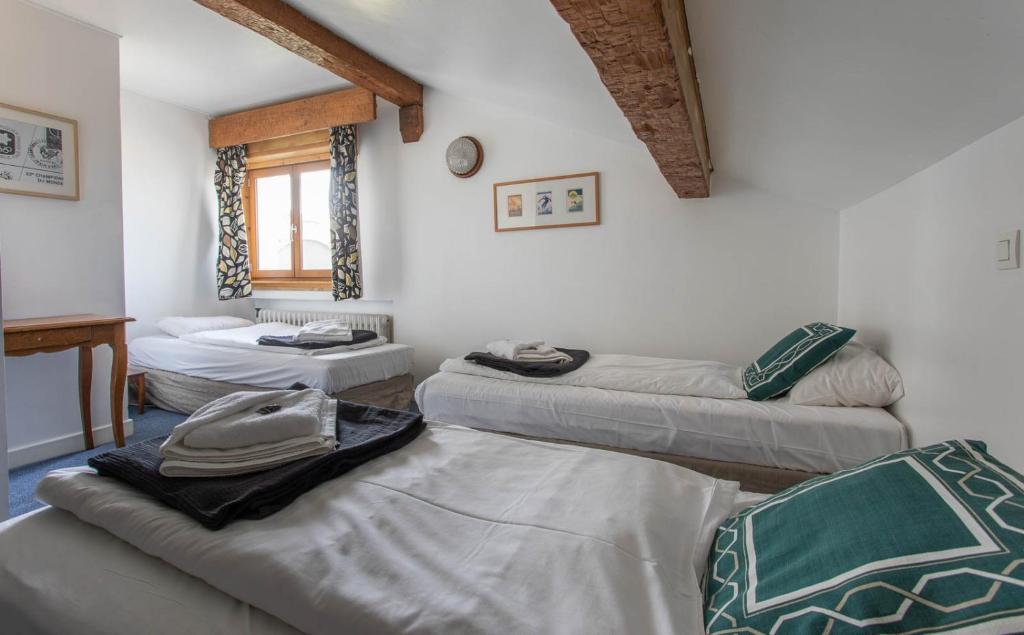 a room with four beds in a room at Hotel Le Chamois in L&#39;Alpe-d&#39;Huez