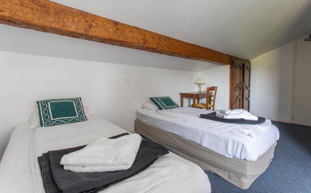 a bedroom with two beds with towels on them at Hotel Le Chamois in L&#39;Alpe-d&#39;Huez