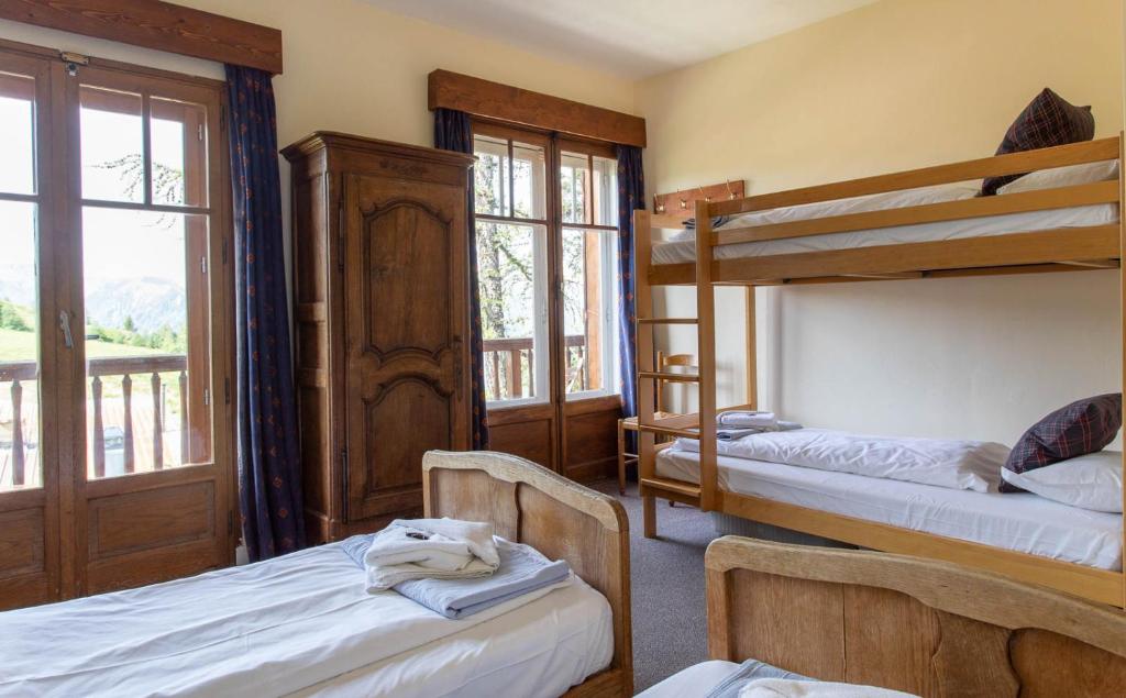 a bedroom with two bunk beds and a balcony at Hotel Le Chamois in L&#39;Alpe-d&#39;Huez