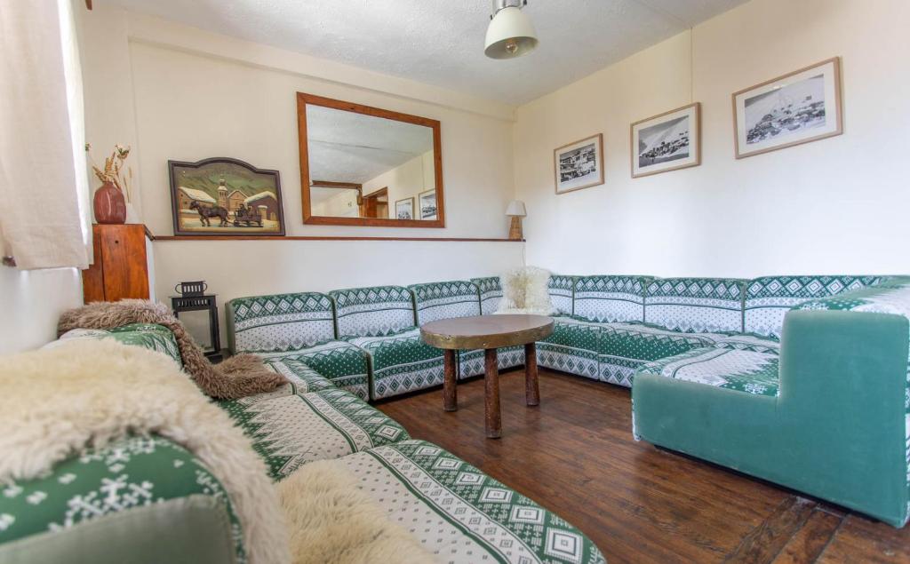 a living room with blue couches and a table at Hotel Le Chamois in L&#39;Alpe-d&#39;Huez