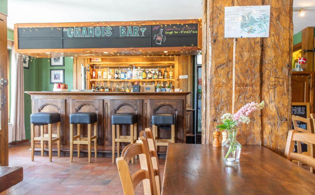 a restaurant with a wooden bar with a wooden table and chairs at Hotel Le Chamois in L&#39;Alpe-d&#39;Huez