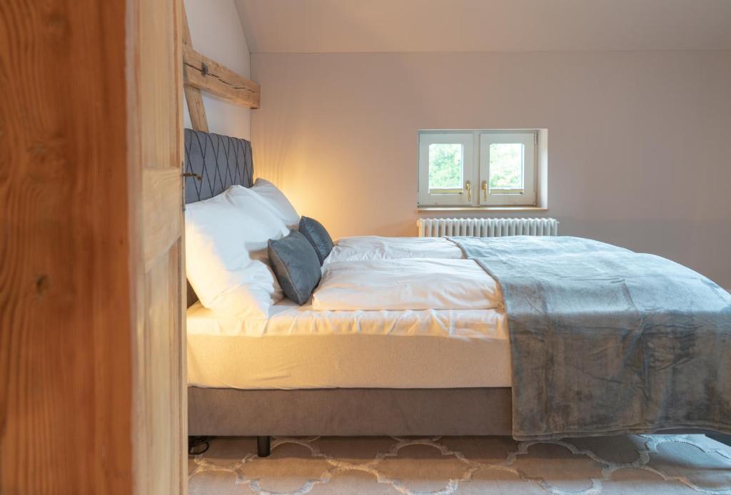 a bedroom with a bed with white sheets and a window at Villa Weber - self check-in in Aarburg