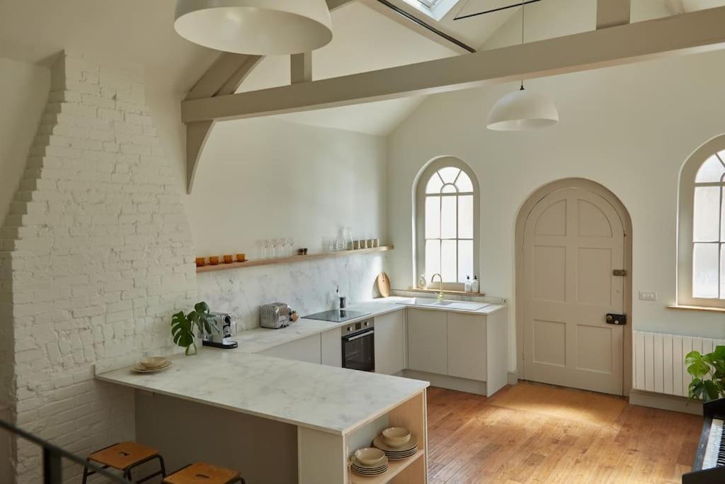 a kitchen with white walls and a white counter top at Converted Chapel with Scandi design interior in New Buckenham