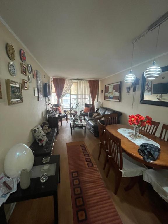 a living room with a table and a couch at Departamento en Condominio Cerrado La Florida in Santiago