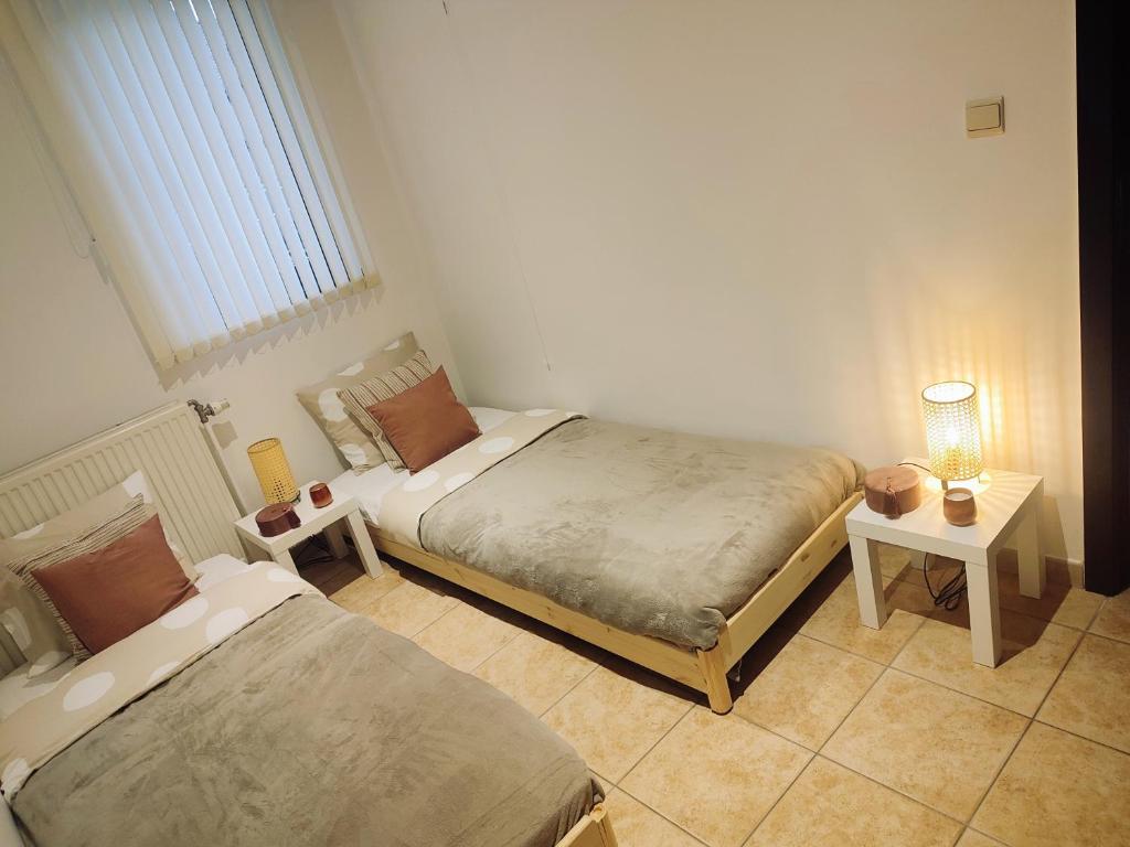 sypialnia z 2 łóżkami i stołem z lampką w obiekcie L auberge de l Entre Potes-Boho Chic w mieście Maffle