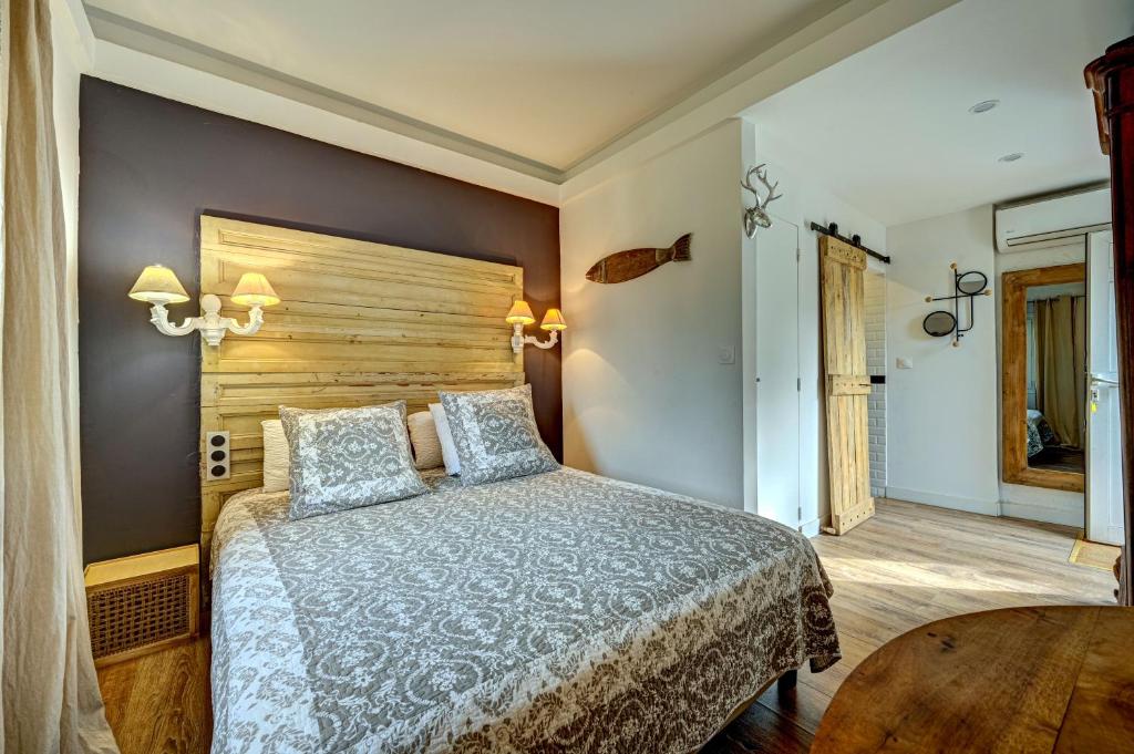 - une chambre avec un grand lit et une tête de lit en bois dans l&#39;établissement Le Provence, à Gémenos