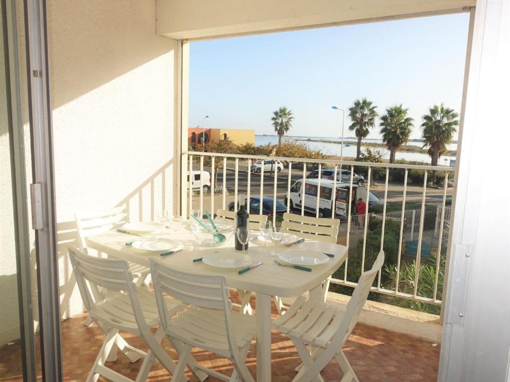 einen weißen Tisch mit weißen Stühlen auf dem Balkon in der Unterkunft Apartment Maisons sur la Plage-1 by Interhome in Gruissan