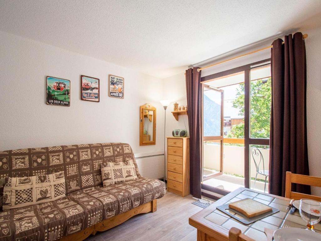 un salon avec un canapé et une fenêtre dans l'établissement Apartment Chalets du Soleil-21 by Interhome, à Les Deux Alpes
