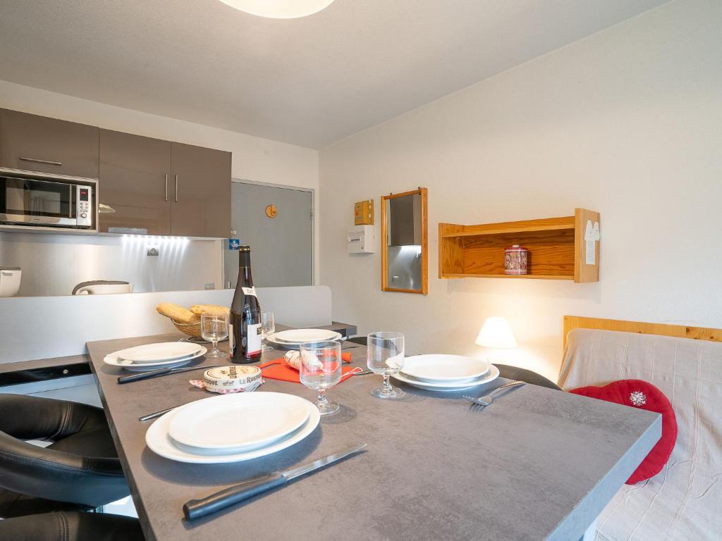 a kitchen with a table with plates and wine glasses at Apartment Le Jettay-15 by Interhome in Les Menuires