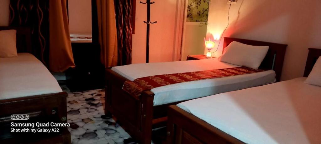 ジャフナにあるGreen star villaの小さなベッドルーム(ベッド2台、ランプ付)