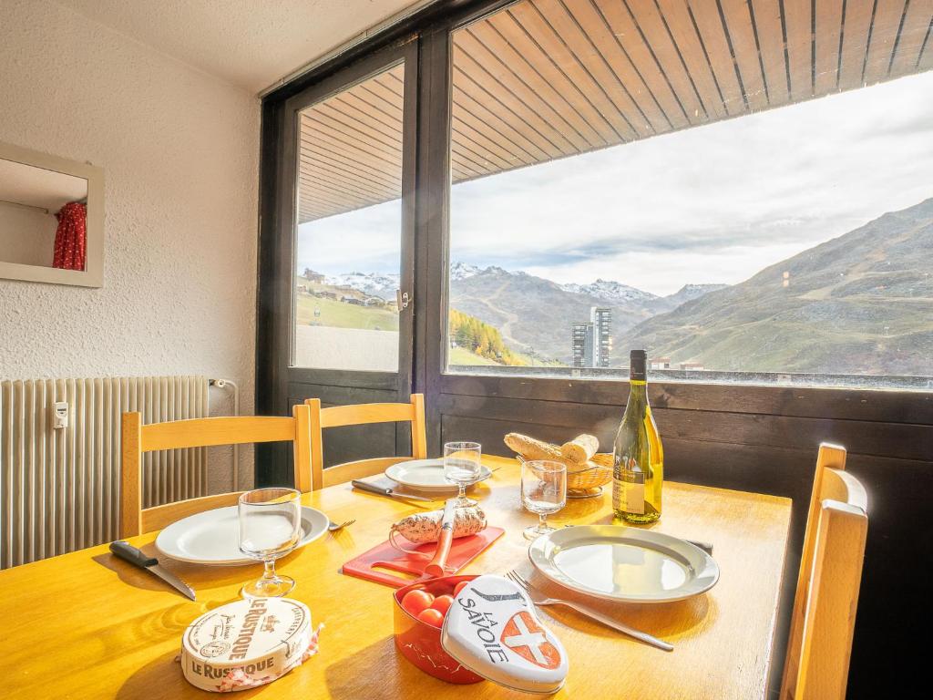 a dining room table with a bottle of wine and glasses at Apartment Pelvoux-2 by Interhome in Les Menuires