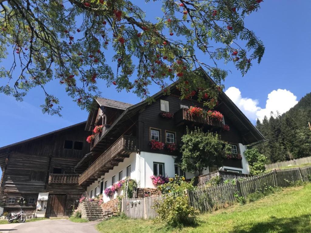 a large black and white house with flowers at Apartment Knaushof - RMU200 by Interhome in Ramsau am Dachstein