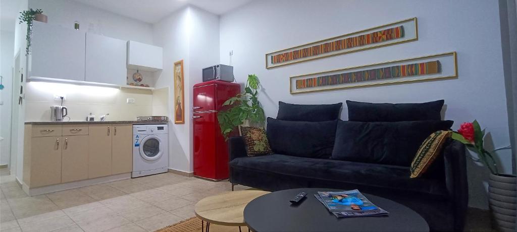 a living room with a couch and a kitchen at Next to the marina in Ashqelon